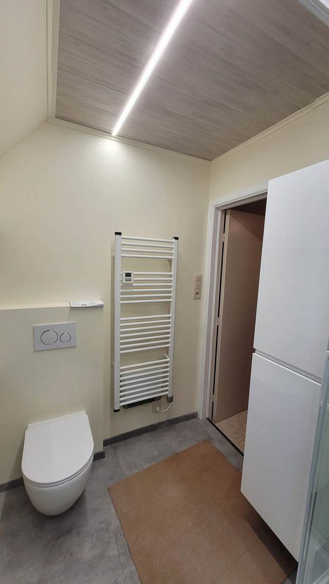 Afgewerkte badkamerrenovatie met handdoekradiator door TSKR BV